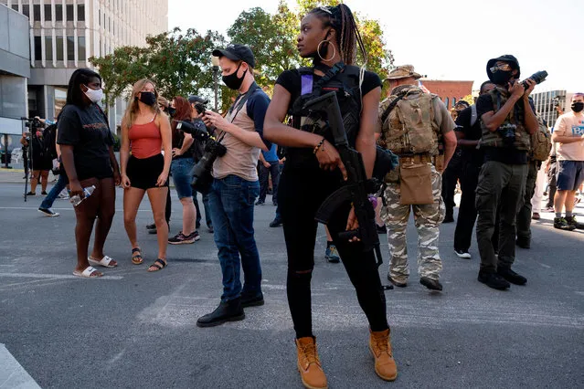 A counter-protester stands in front of the Louisville, Kentucky, courthouse, as patriot militia members march in support of local police officers on September 5, 2020. (Photo by Jeff Dean/AFP Photo)