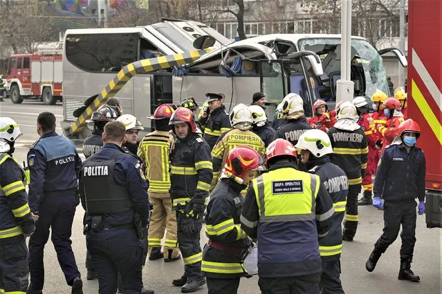 Emergency service employees stand around a bus carrying 47 Greek citizens which crashed into a height limit bar at the entrance of a tunnel in Bucharest, Romania, Friday, December 23, 2022. The head of Romania's Department for Emergency Situations (DSU) Raed Arafat told reporters that 22 people were hospitalized, one person died and one is in a critical condition. (Photo by Vadim Ghirda/AP Photo)