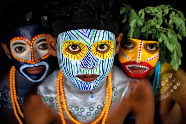 Young children pose with their faces painted during the event on June 15, 2025 in India. For generations Bahurupi artists from West Bengal have been practicing in the art of face painting. Using their painting techniques they can easily metamorphose into different characters during a performance, which often represents tribal myths. These traditional artists scrape a living from their performances, relying on the generosity of audiences for their income. (Photo by Avishek Das/SOPA Images/Rex Features/Shutterstock)
