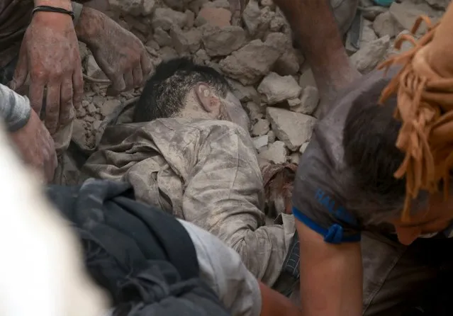 Syrians try to rescue a dead body under the debris of a collapsed building after Syrian and Russian army carried out an airstrike on opposition controlled residential area at Merce neighborhood of Aleppo, Syria on September 23, 2016. (Photo by Jawad al Rifai/Anadolu Agency/Getty Images)