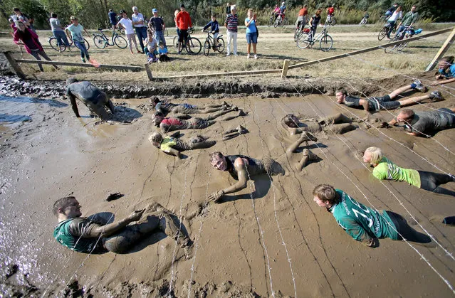 Hobby athletes in action during the “Cross De Luxe” run at Markkleeberger See near Leipzig, Germany, 25 September 2016. More than 3,000 athletes participated during two days in the 8 or 16 kilometer run through water pools, pipes and mud walls. (Photo by Jan Woitas/EPA)
