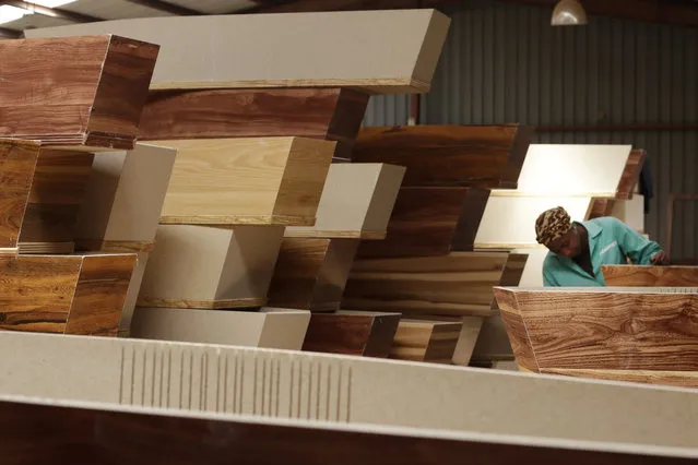 A worker carries out her duties among stacked coffins at Enzo Wood Designs, in Johannesburg, Wednesday, September 30. 2020. Kasie Pillay, a coffin-maker in South Africa, watched the coronavirus pandemic turn his business upside down. For Pillay, the need for coffins rose and fell as South Africa's lockdown levels changed, but overall, he said, “business went down”. As the world surpasses 1 million deaths, Africa is bracing for a likely second wave of infections. (Photo by Themba Hadebe/AP Photo)