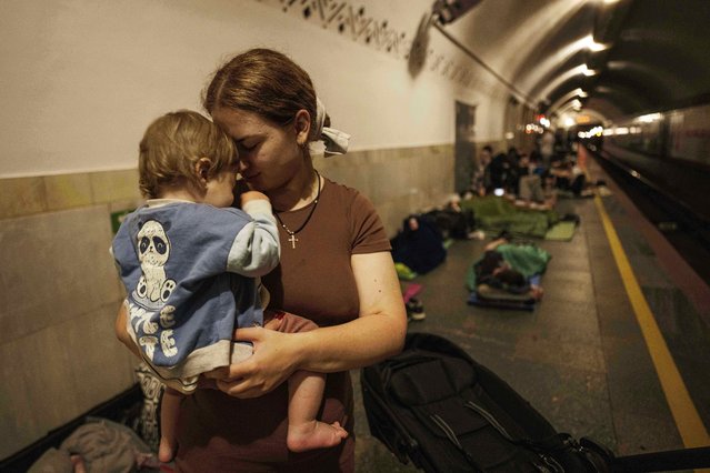 Oleksandra Umanets, 23, calms her 10-month-old son as they take cover on the platform of a metro station during a Russian attack on Kyiv, Ukraine, on Thursday, July 10, 2025. (Photo by Evgeniy Maloletka/AP Photo)