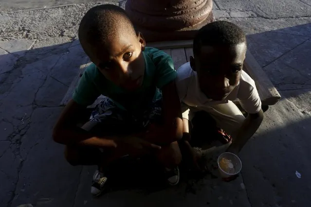 Children sit on the sidewalk during sunset in Havana October 26, 2015. (Photo by Reuters/Stringer)