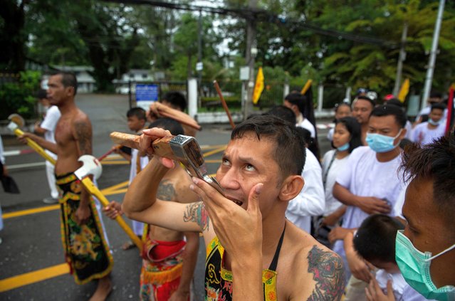 Thai devotees who are possessed by spirits cut their tongues during the first street procession of the Vegetarian Festival held at the Choor Su Gong Shrine on October 18, 2020 in Phuket, Thailand. (Photo by Lauren DeCicca/Getty Images)