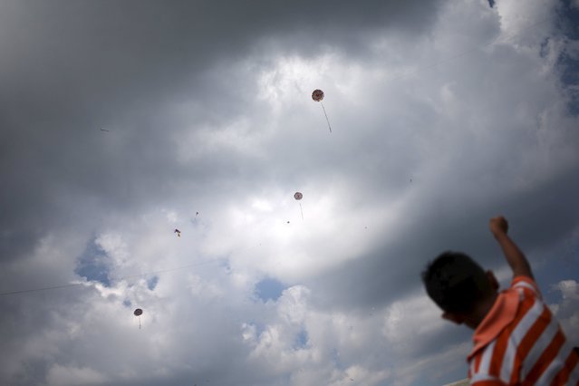 A child flies a kite in the cemetery of Santiago Sacatepequez, Guatemala, November 1, 2015. (Photo by Jorge Dan Lopez/Reuters)