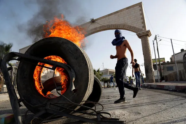 A Palestinian protester takes position near burning tyres during clashes with Israeli troops in the West Bank town of Al-Ram, near Jerusalem October 9, 2016. (Photo by Mohamad Torokman/Reuters)