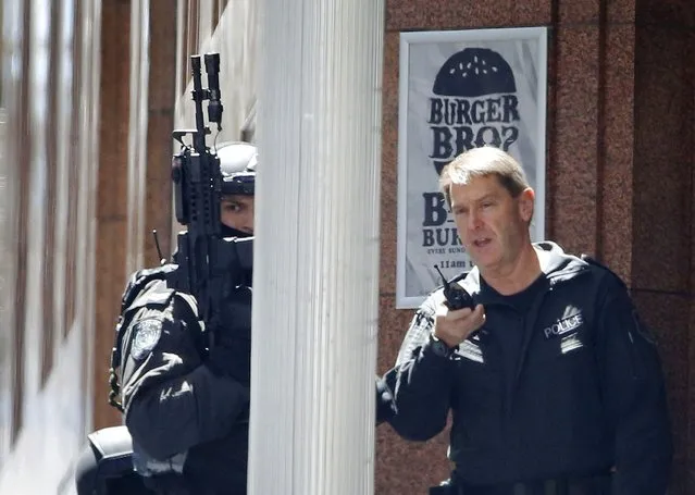 Police officers are seen at a corner near Lindt cafe in Martin Place, where hostages are being held, in central Sydney December 15, 2014. (Photo by Jason Reed/Reuters)