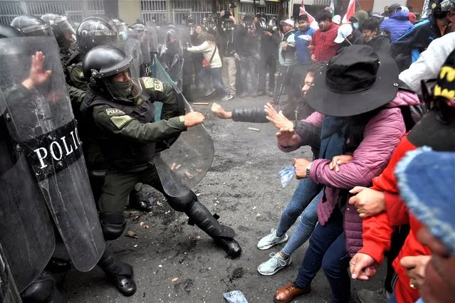 Teachers clash with police officers during a protest against a new curriculum set by Bolivia's Ministry of Education, in La Paz, Bolivia on March 21, 2023. (Photo by Claudia Morales/Reuters)
