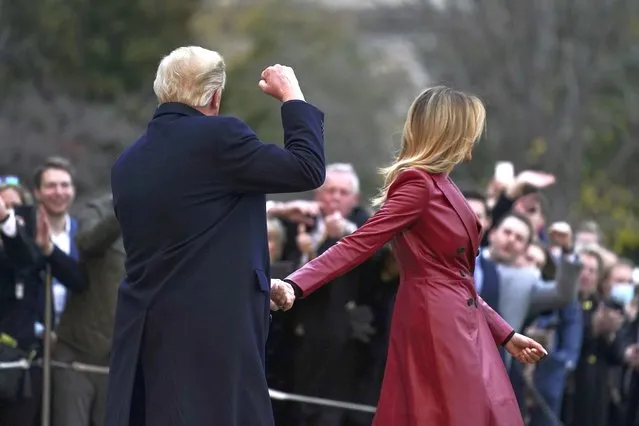 President Donald Trump gestures to supporters as he and first lady Melania Trump walk on the South Lawn of the White House in Washington, Saturday, December 5, 2020, before boarding Marine One for a short trip to Andrews Air Force Base, Md. Trump is en route to Georgia for a rally for U.S. Senate candidates David Perdue and Kelly Loeffler. (Photo by Patrick Semansky/AP Photo)