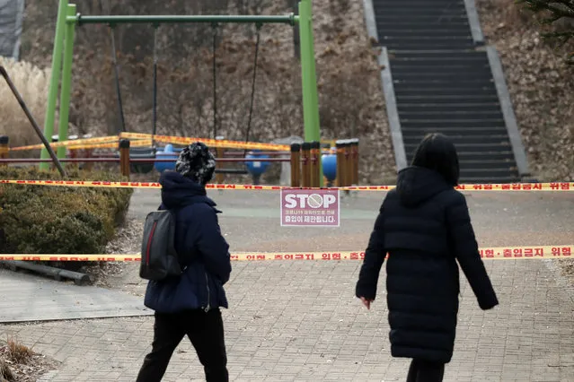 Visitors look at a playground, which is taped off for the social distancing measures and a precaution against the coronavirus at a park in Seoul, South Korea, Wednesday, December 23, 2020. South Korea has added more than 1,000 new coronavirus cases in a resurgence that is erasing hard-won epidemiological gains and eroding public confidence in the government’s ability to handle the outbreak. (Photo by Lee Jin-man/AP Photo)