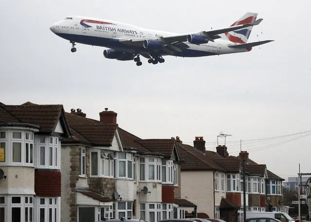 A plane approaches landing over the rooftops of nearby houses at Heathrow Airport in London, Tuesday, October 25, 2016. Britain's government will reveal how it plans to expand London's airport capacity, more than a year after a special commission recommended a third runway at Heathrow. (Photo by Frank Augstein/AP Photo)