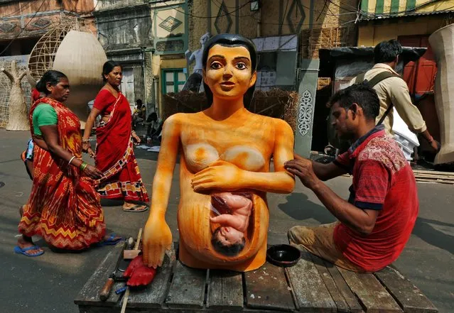 An artisan paints a model of a pregnant woman that will be placed at a pandal, or a temporary platform, ahead of the Kali Puja festival in Kolkata, India October 26, 2016. (Photo by Rupak De Chowdhuri/Reuters)