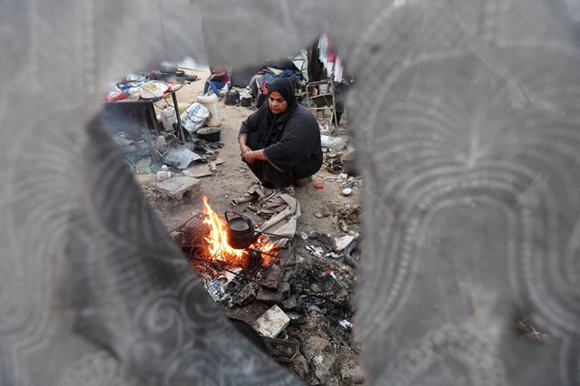 A Palestinian woman makes tea over the fire, amid the ceasefire between Israel and Hamas, in Khan Younis in the southern Gaza Strip, on November 18, 2025. (Photo by Ramadan Abed/Reuters)