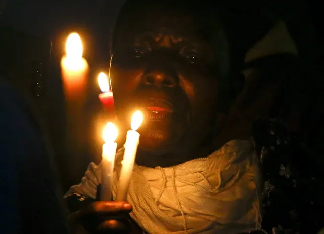 A faithful holds candles before Pope Francis' arrival in Munyonyo in Kampala, Uganda, November 27, 2015. (Photo by Stefano Rellandini/Reuters)