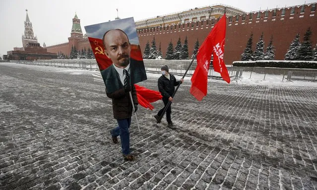 Russian communists carry a portrait of Vladimir Lenin and wave red flags during a commemoration for the 97th death anniversary of the founder of the former Soviet Union, near his mausoleum on the Red Square in Moscow, Russia, 21 January 2021. Lenin, who died in 1924, was placed in the mausoleum despite his wish to be buried near his mother at Volkovo cemetery in St. Petersburg. (Photo by Sergei Ilnitsky/EPA/EFE)