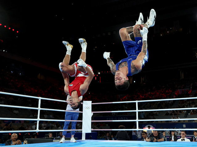 Abdumalik Khalokov of Team Uzbekistan and Charlie Senior of Team Australia perform synchronised back flips after the Boxing Men's 57kg Semifinal match on day thirteen of the Olympic Games Paris 2024 at Roland Garros on August 08, 2024 in Paris, France. (Photo by Richard Pelham/Getty Images)