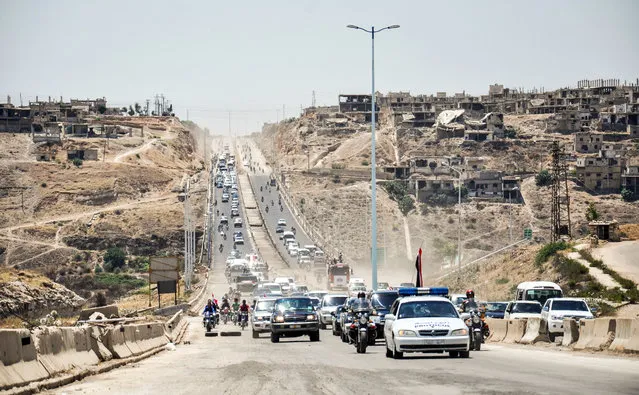 A picture taken on June 6, 2018 in the central Syrian province of Homs shows government cars and military vehicles driving along the main highway between Homs and Hama. The Homs-Hama highway was restored and re-opened after reportedly being closed for around seven years, according to the official Syrian Arab News Agency (SANA). (Photo by AFP Photo/Stringer)