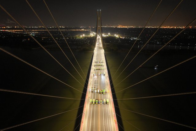 Loaded trucks drive on the Baguazhou Yangtze river bridge for a safety test inspection in Nanjing, China's eastern Jiangsu province on December 18, 2024. (Photo by AFP Photo/China Stringer Network)