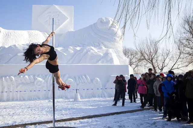 A woman named Yu Fei pole dances at a park in cold weather on January 19, 2015 in Changchun, Jilin province of China. Yu Fei, 26, who has practiced pole dancing for 6 years performs pole dancing in a public park to try to help promote the activity. (Photo by ChinaFotoPress/ChinaFotoPress via Getty Images)