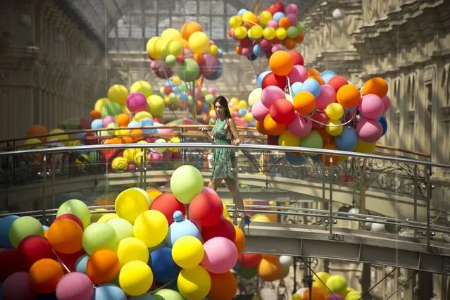 A woman crosses a bridge at GUM, one of the oldest department stores in central Moscow, on July 11, 2013. (Photo by Natalia Kolesnikova/AFP Photo)