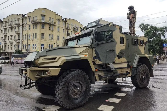 A serviceman stands atop of an armored vehicle of the Wagner Group military company, as he guards an area at the HQ of the Southern Military District in a street in Rostov-on-Don, Russia, Saturday, June 24, 2023. Russia's security services had responded to Prigozhin's declaration of an armed rebellion by calling for his arrest. In a sign of how seriously the Kremlin took the threat, security was heightened in Moscow, Rostov-on-Don and other regions. (Photo by AP Photo/Stringer)