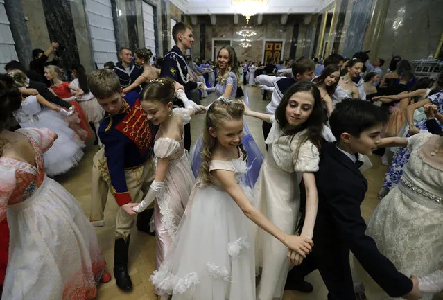 Participants dance during the Winter Ball in Mikhailovsky Castle in St. Petersburg, Russia, 27 December 2016. Pupils of the Russian Vaganova's Ballet Academy and cadets of the Suvorov's  Military School and the Naval College gathered for the first Winter Ball, restoring an old tradition of Russian officers and noble girls. (Photo by Anatoly Maltsev/EPA/EFE)