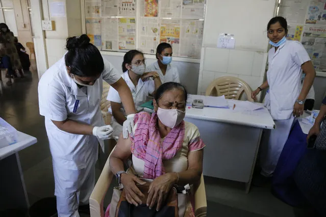 A woman reacts as she receives a shot of the Covishield COVID-19 vaccine at Sola Civil hospital in Ahmedabad, India, Wednesday, March 3, 2021. The COVID-19 vaccination drive for senior citizens and those above 45 years of age with comorbidities began in government and designated private hospitals in Gujarat on Monday along with the rest of the country. (Photo by Ajit Solanki/AP Photo)