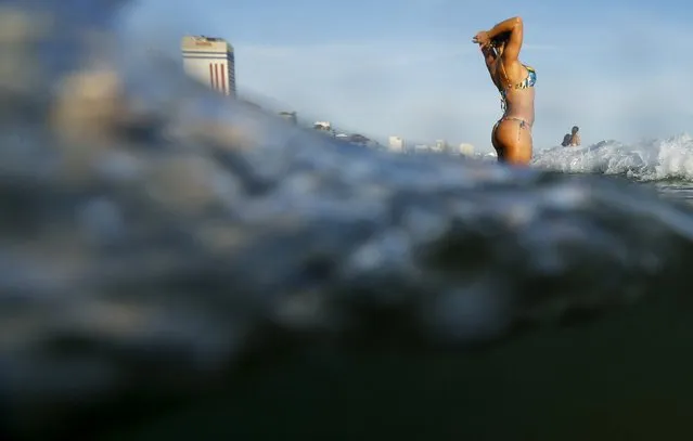 A woman gets into the waters on Leblon beach at Rio de Janeiro, Brazil, December 22, 2015. With the arrival of summer in the southern hemisphere, average daytime temperatures in Rio have reached into the mid-to-upper 38's Celsius (upper 100's Fahrenheit), local media reported. (Photo by Ricardo Moraes/Reuters)