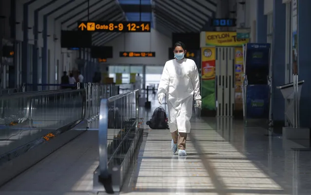 A Sri Lankan airport worker in protective suit walks inside a terminal at the Katunayake International Airport in Colombo, Sri Lanka, Wednesday, January 20, 2021. Sri Lanka's tourism minister said that the airports in the country will be reopened for tourists according to health guidelines from Jan.21. (Photo by Eranga Jayawardena/AP Photo)