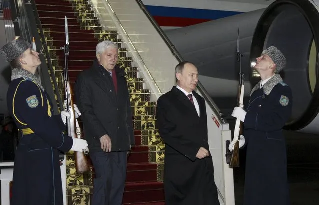 Russian President Vladimir Putin (2R) walks past soldiers from the guard of honour during a welcoming ceremony at an airport near Minsk, February 11, 2015. (Photo by Valentyn Ogirenko/Reuters)