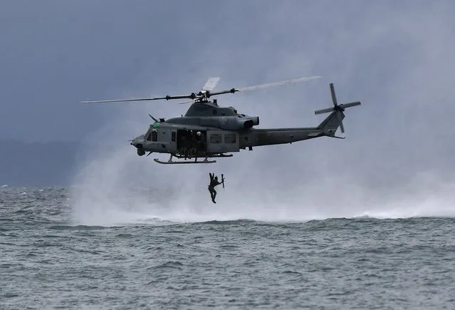 A Philippines marine jumps off from a US marines UH-1Y Venom helicopter during a helocast and maritime patrol training exercise as part of the semi-annual Philippine-US military exercise dubbed Marine Aviation Support Activity (MASA) 23, off a marine training base in Ternate town, Cavite province, north of Manila on July 14, 2023. (Photo by Ted Aljibe/AFP Photo)