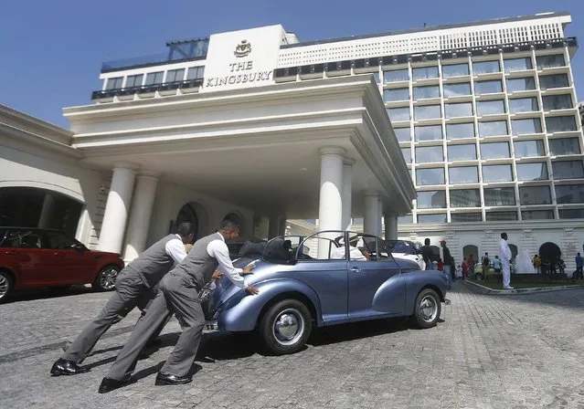 Two men push a broken British-made classic Morris Minor car during the “British Car Day” rally in Colombo February 15, 2015. Over 100 British-made classic cars participated in the rally to celebrate British Car Day in Sri Lanka. (Photo by Dinuka Liyanawatte/Reuters)