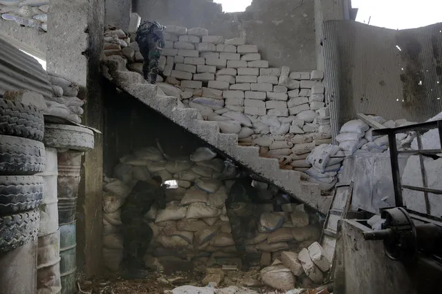 Syrian army soldiers fire their weapons during a battle with rebels at the Ramouseh front line, east of Aleppo, Syria, Monday, December 5, 2016. (Photo by Hassan Ammar/AP Photo)