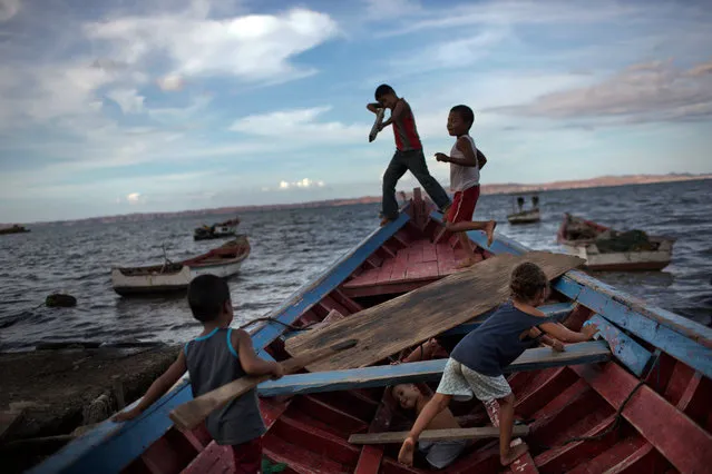 In this November 9, 2016 photo, children play “pirates” on a fishing boat in Cumana, Sucre state, Venezuela. “You hear piracy and you think of guys robbing container ships in Africa. But here it's just poor fishermen robbing other poor fishermen”, said Sucre lawyer Luis Morales. “It's the same kind of crime we've seen in the streets, but spreading to the sea”. (Photo by Rodrigo Abd/AP Photo)