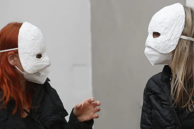 Participants talk before taking part in an Easter procession marching through the streets in Ceske Budejovice, Czech Republic, Thursday, April 1, 2021. The traditional event went ahead despite COVID-19 restrictions, although participants also wore medical face masks and observed social distancing as a precaution. (Photo by Petr David Josek/AP Photo)