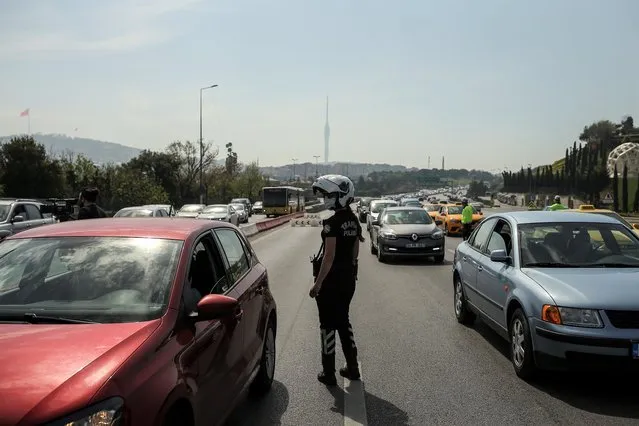 Police inspect passengers in vehicles on the July 15 Martyrs' Bridge, formerly known as the Bosphorus Bridge in Istanbul, Friday, April 30, 2021, on the first day of a tight lockdown to help protect from the spread of the coronavirus. (Photo by Emrah Gurel/AP Photo)