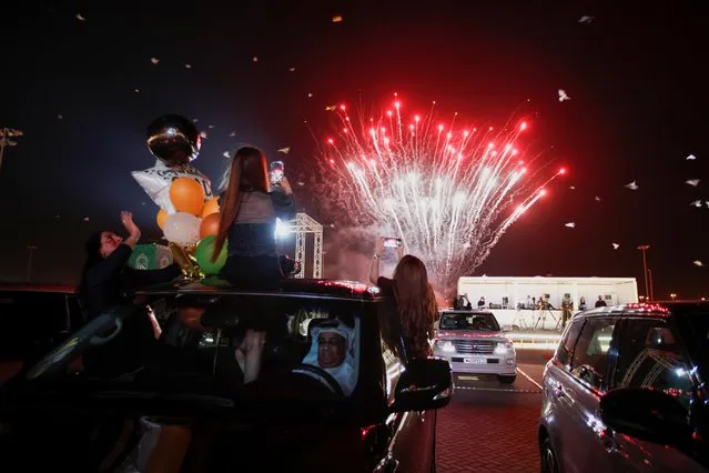 Family members take pictures of fireworks from a car during The Visual Graduation Ceremony 2021 of Bahrain Bayan School at Bahrain International Circuit parking lot in Sakhir, Bahrain, May 23, 2021. (Photo by Hamad I Mohammed/Reuters)