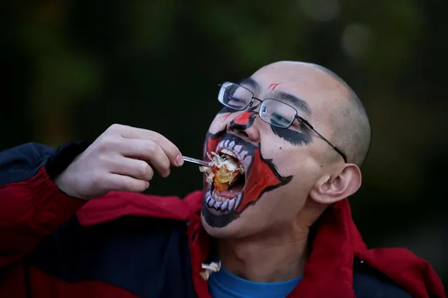A participant in costume eats before a Halloween event at Happy Valley park in Beijing, China, October 31, 2018. (Photo by Jason Lee/Reuters)