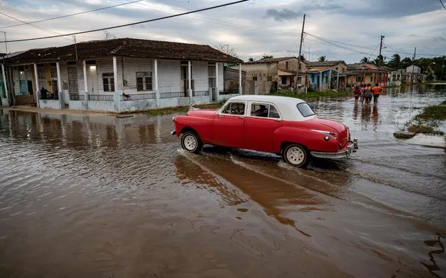 An old American car passes through a flooded area of Batabano, Mayabeque Province, Cuba, on August 28, 2023, as Tropical Storm Idalia approaches the western tip of the island nation. Tropical Storm Idalia strengthened as it neared Cuba and the abnormally hot waters of the Gulf of Mexico on Monday, with forecasters predicting it could become a major hurricane before roaring ashore in Florida this week. (Photo by Yamil Lage/AFP Photo)