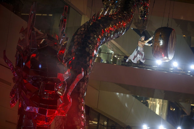 A drummer performs next to a giant dragon sculpture as part of the festive Chinese Lunar New Year celebrations in Bangkok's shopping district, Thailand, February 4, 2016. (Photo by Athit Perawongmetha/Reuters)