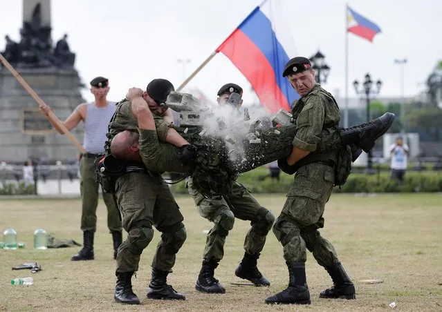 A Russian Marine uses a hammer to break a brick on top of his comrade's stomach during a Capability Demonstration at Manila's Rizal Park, Philippines on Thursday, January 5, 2017. Russia is eyeing naval exercises with the Philippines and deployed two navy ships for a goodwill visit to Manila as Moscow moves to expand defense ties with the country. (Photo by Aaron Favila/AP Photo)