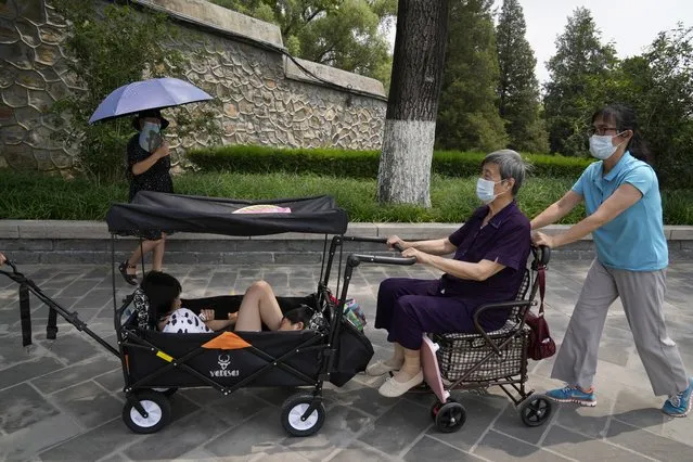 Tourists wear face masks as they visit the Summer Palace in Beijing Tuesday, August 3, 2021. The current coronavirus outbreaks in China, while still in the hundreds of cases in total, have spread much more widely than previous ones, reaching multiple provinces and cities including the capital, Beijing. Many of the cases have been identified as the highly contagious delta variant that is driving a resurgence in many countries. (Photo by Ng Han Guan/AP Photo)
