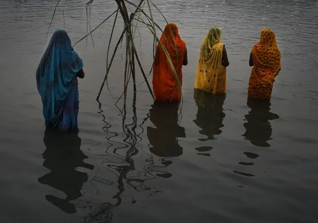 Hindu devotees pray in the river Yamuna to during Chhath Puja festival in New Delhi, Sunday, October 30, 2022. During Chhath, an ancient Hindu festival, rituals are performed to thank the Sun god for sustaining life on earth. (Photo by Manish Swarup/AP Photo)