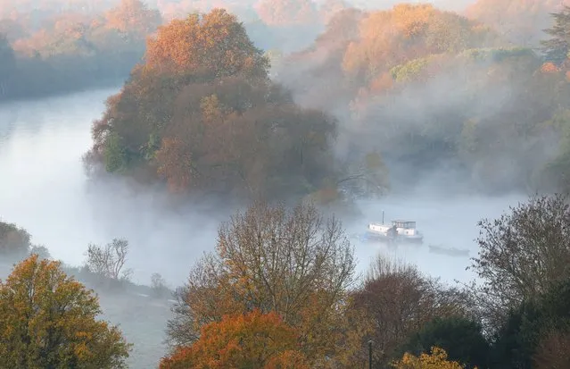 Autumn foliage is seen as mist surrounds a barge anchored on the River Thames in Richmond in London, Britain on November 17, 2023. (Photo by Toby Melville/Reuters)