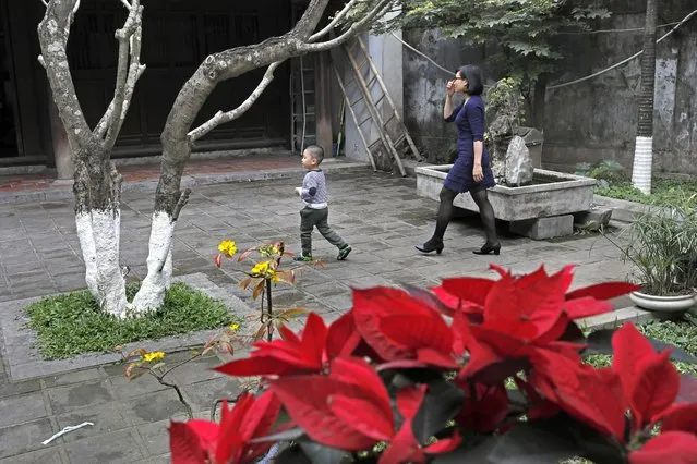 A woman and a boy walk at the Quan Thanh Temple in Hanoi, Vietnam, Sunday, February 24, 2019. As Vietnam's capital gears up for the second summit between U.S. President Donald Trump and North Korean leader Kim Jong Un, people leave offerings at temples, snap selfies and buy snacks in Hanoi. (Photo by Vincent Yu/AP Photo)