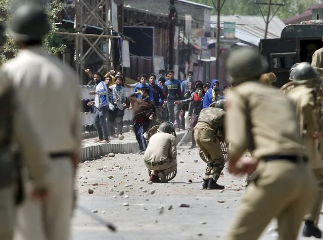 Kashmiri protesters throw stones towards Indian policemen during a daylong protest strike in Narbal, north of Srinagar April 18, 2015. One person died on Saturday in Kashmir following an injury suffered after police opened fire to disperse stone-throwing demonstrators during a daylong protest strike over the arrest of a separatist leader. (Photo by Danish Ismail/Reuters)