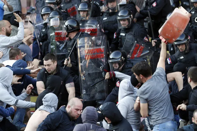 Serbian riot police officers clash with Red Star soccer fans during a Serbian National soccer league derby match between Red Star and Partizan, in Belgrade, Serbia, Saturday, April 25, 2015. (Photo by Darko Vojinovic/AP Photo)