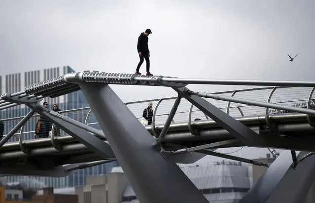 A man balances as he walks on the support structure of the Millennium Bridge, over the River Thames, in London, Britain March 6, 2016. (Photo by Peter Nicholls/Reuters)
