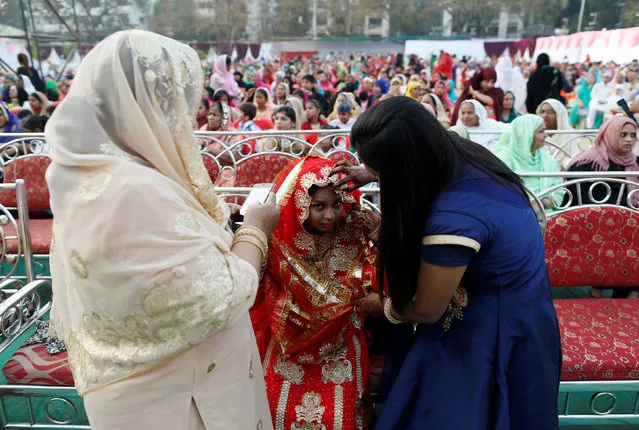 A bride gets ready before a mass marriage ceremony, in which, according to its organizers, 75 Muslim couples took their wedding vows, in Mumbai, India, January 22, 2017. (Photo by Danish Siddiqui/Reuters)
